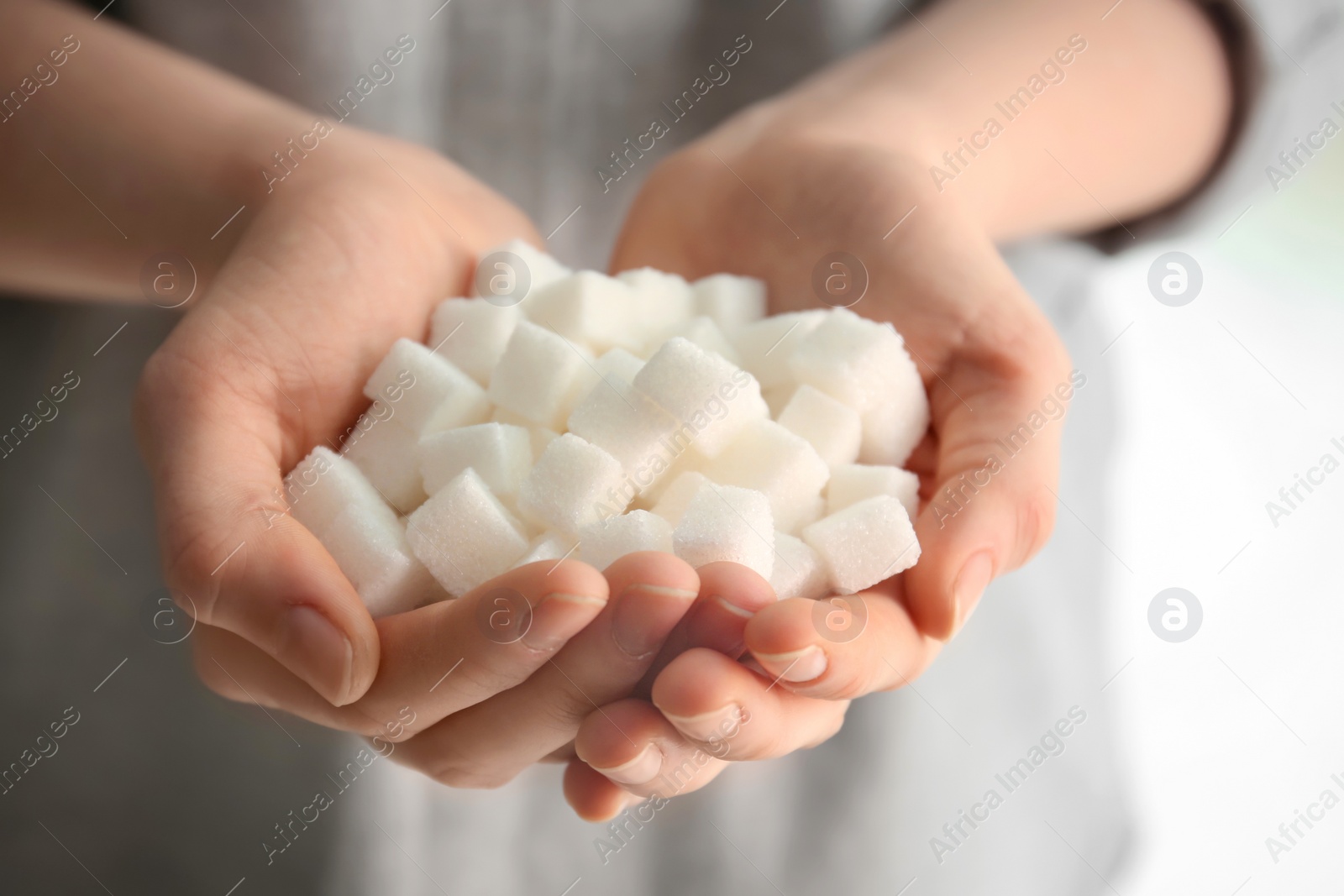 Photo of Woman holding sugar cubes, closeup