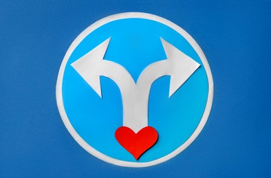 Photo of Divorce concept. Paper heart and arrows on blue background, flat lay