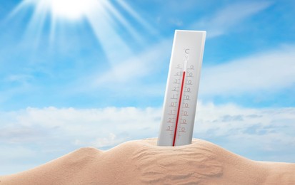 Image of Thermometer in sand showing high temperature during hot summer day