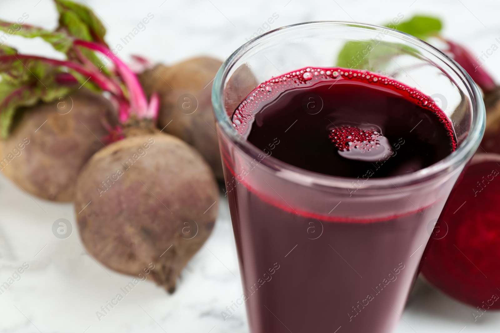 Photo of Freshly made beet juice on table, closeup