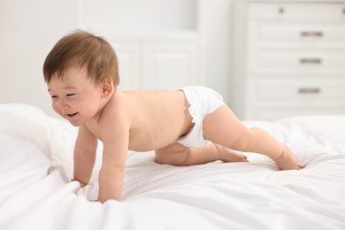 Photo of Happy baby boy crawling on bed at home
