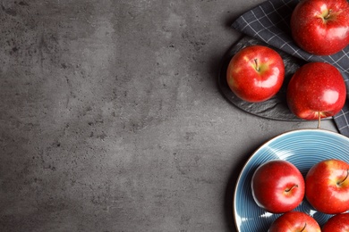 Photo of Flat lay composition with ripe juicy red apples on grey table. Space for text