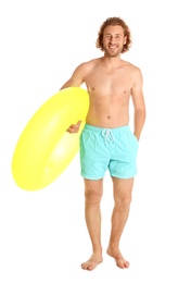 Photo of Attractive young man in swimwear with yellow inflatable ring on white background