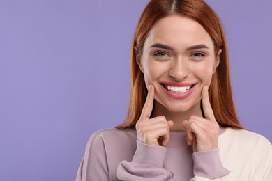 Photo of Beautiful woman showing her clean teeth and smiling on violet background, space for text