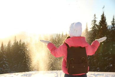 Young woman having fun outdoors on snowy winter day