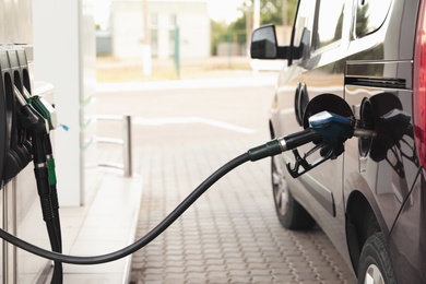 Photo of Refueling modern car at gas filling station, closeup