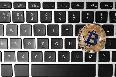 Photo of Golden bitcoin on computer keyboard, top view. Space for text