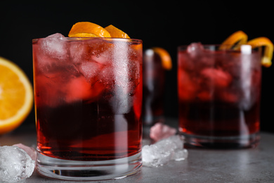 Photo of Fresh Negroni cocktails with orange zest on grey table, closeup