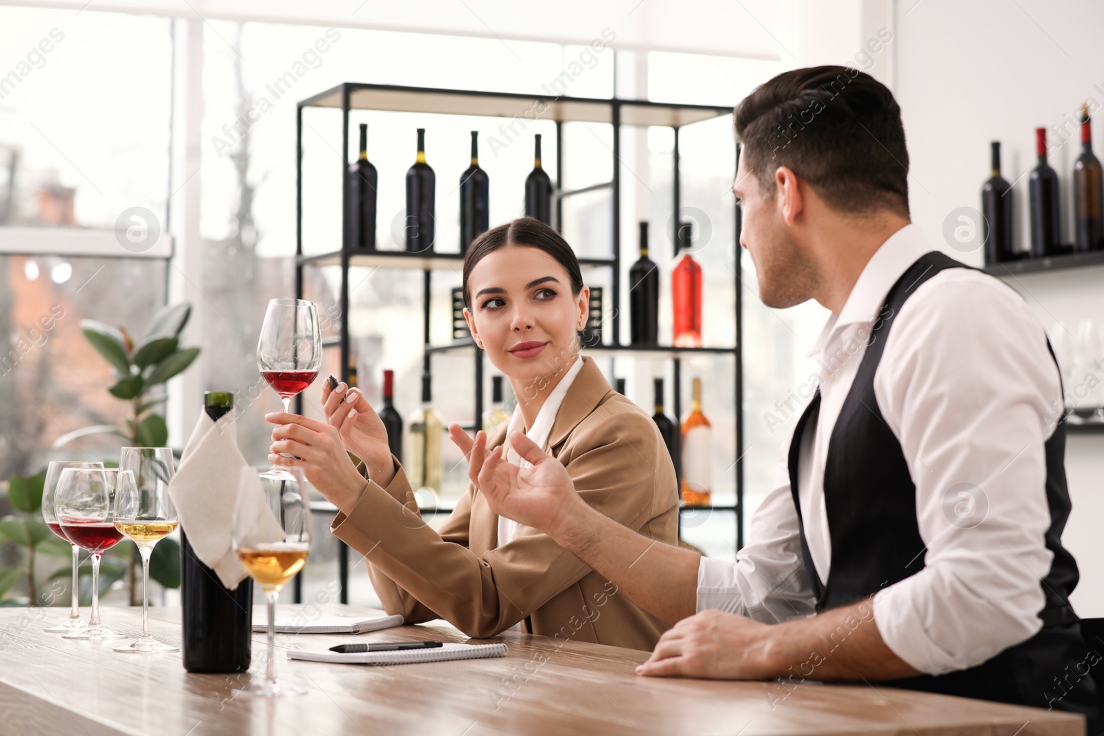 Photo of Sommeliers tasting different sorts of wine at table indoors