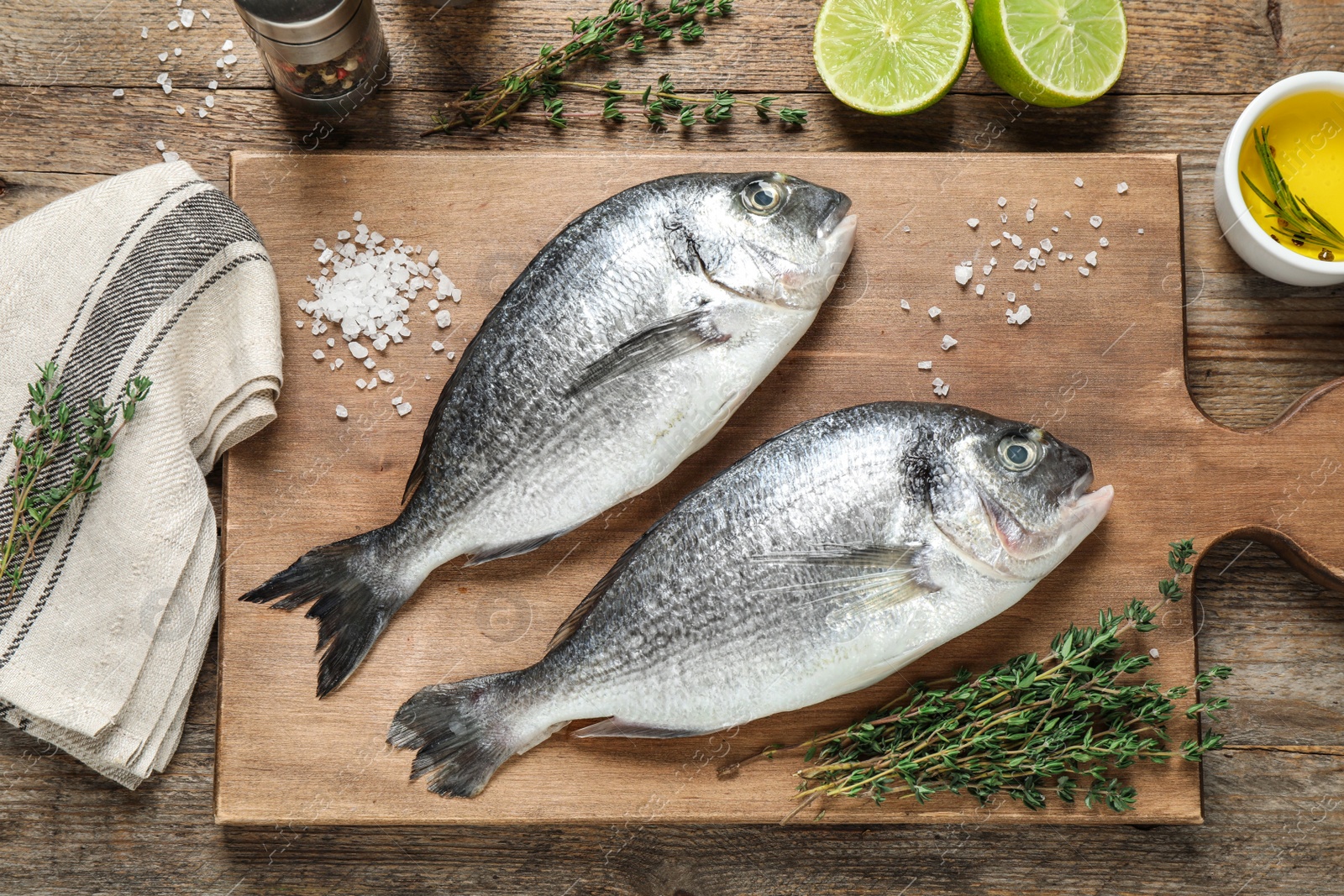 Photo of Raw dorada fish on wooden table, flat lay