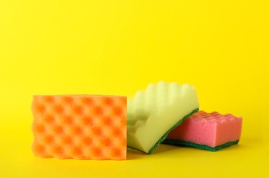 Photo of Three sponges on yellow background. Space for text