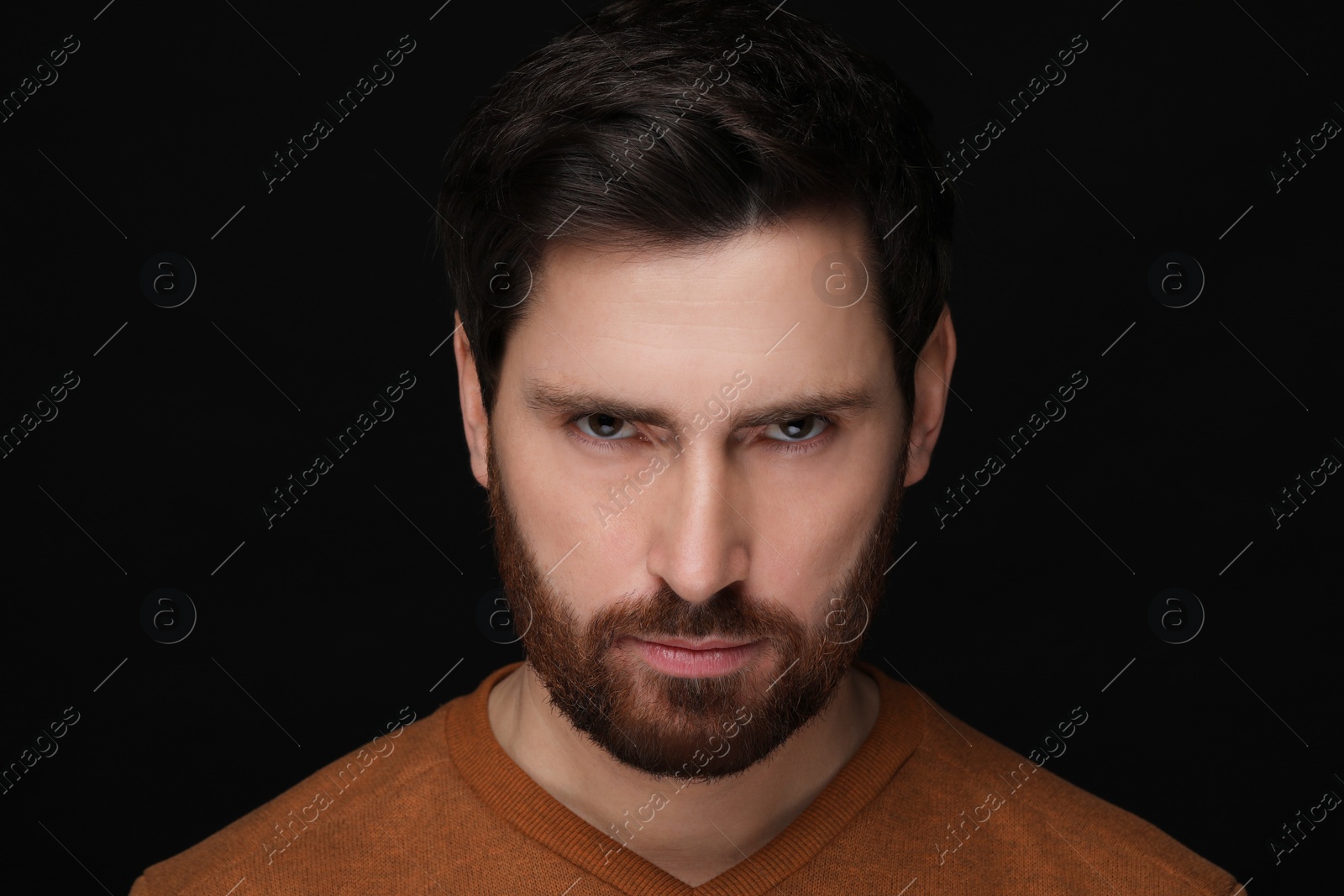 Photo of Evil eye. Man with scary eyes on black background, closeup