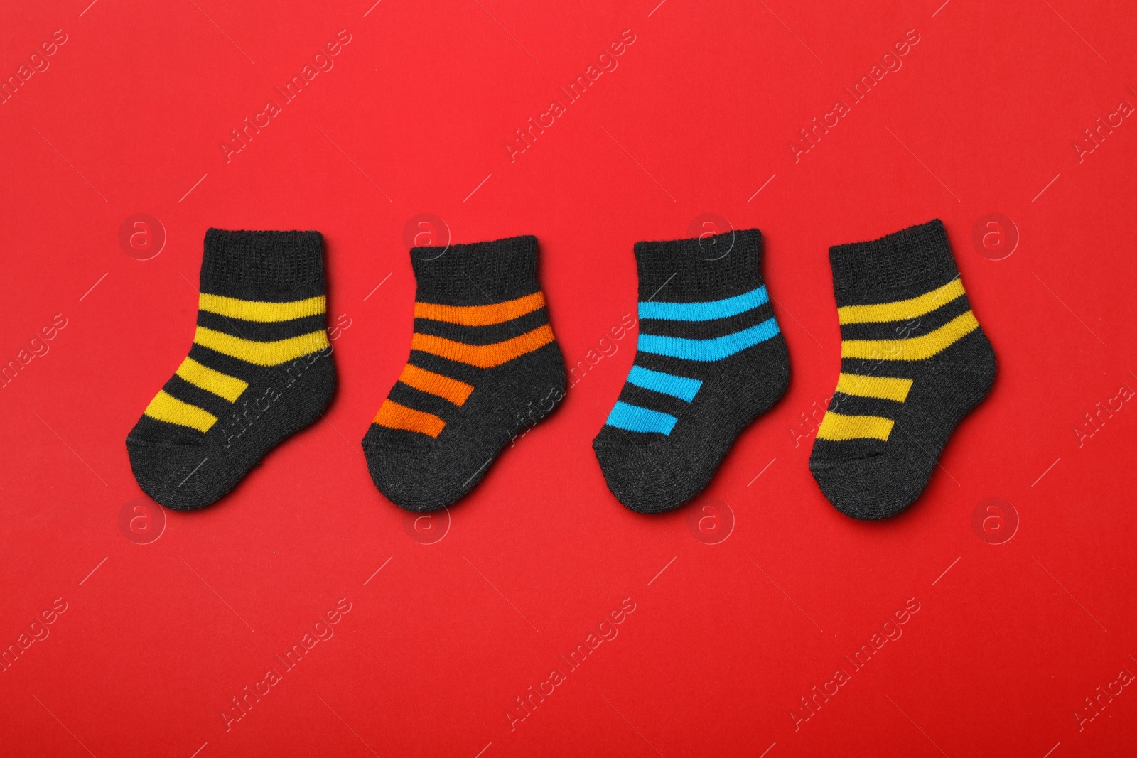 Photo of Cute child socks on color background, flat lay