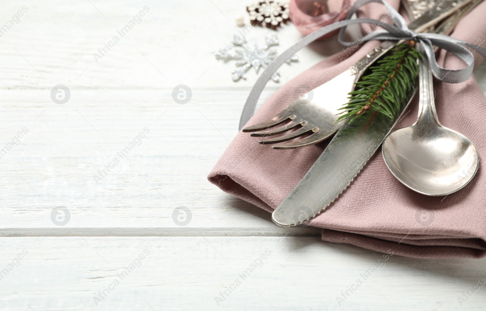 Photo of Cutlery set and festive decor on white wooden table, closeup with space for text. Christmas celebration