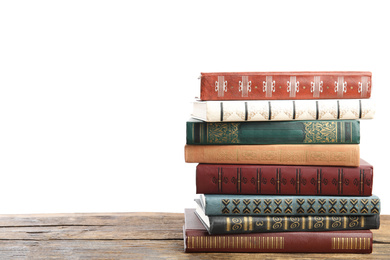 Stack of old vintage books on wooden table against white background