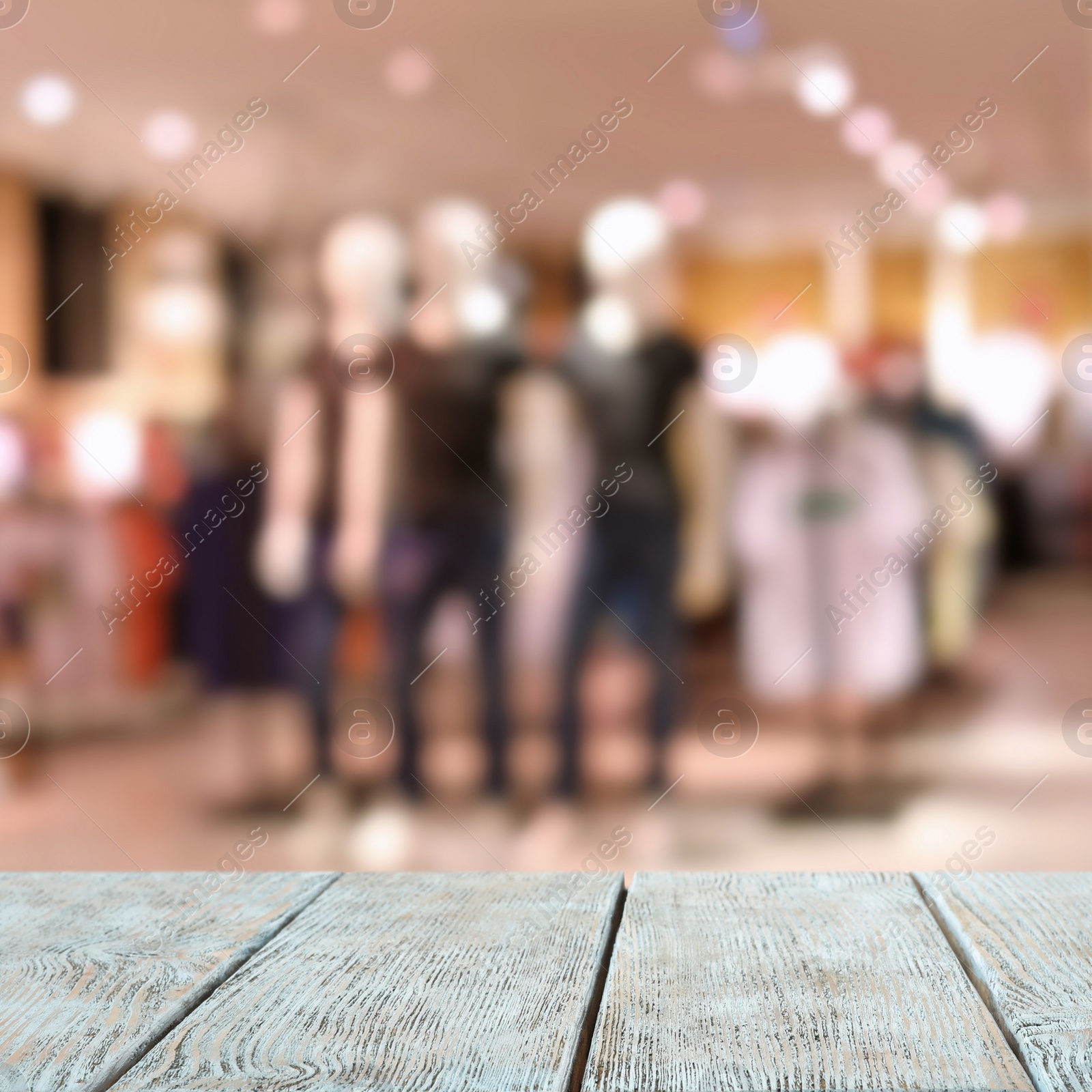 Image of Empty wooden table and blurred view of store with modern clothes