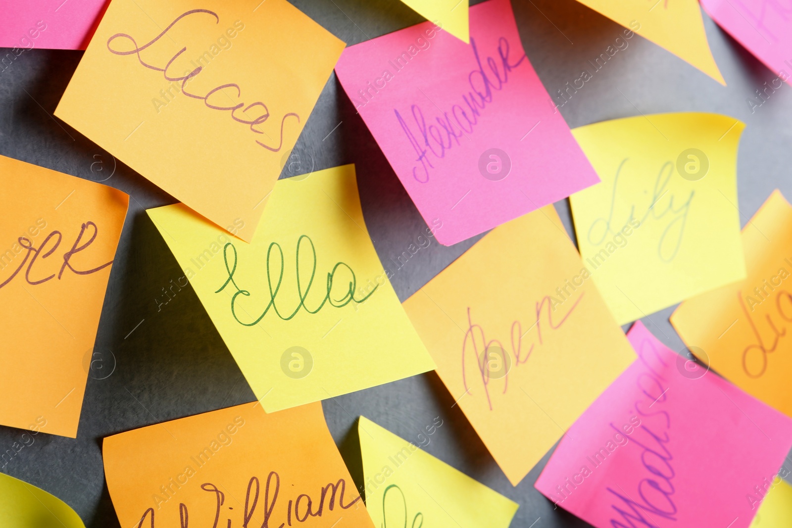 Photo of Paper notes with different baby names on grey wall