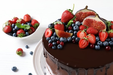 Fresh delicious homemade chocolate cake with berries on light table