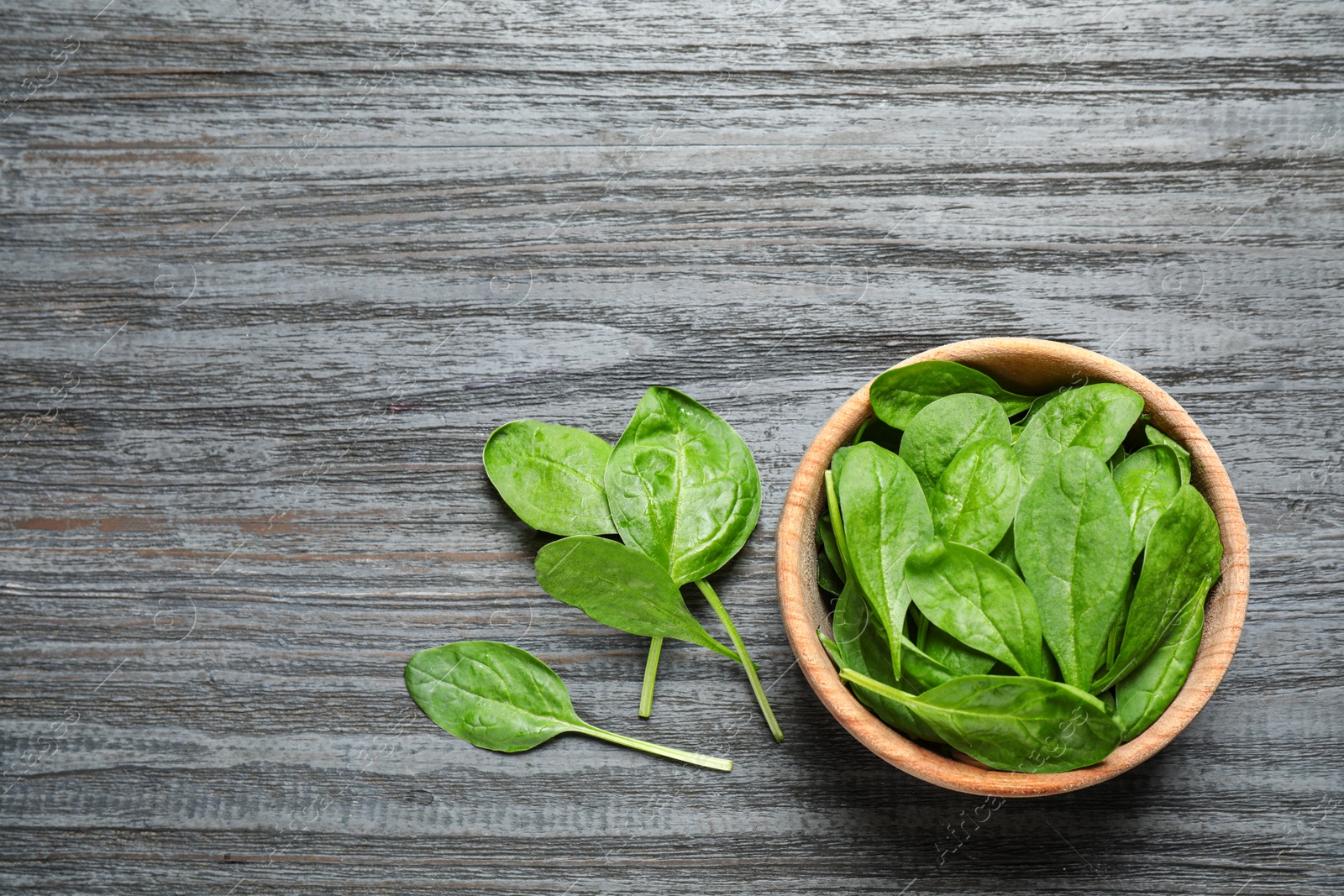 Photo of Fresh green healthy spinach on dark wooden table, flat lay. Space for text