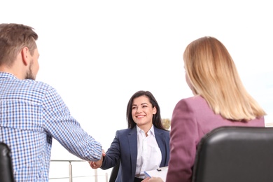 Photo of Human resources manager shaking hands with applicant during job interview in office