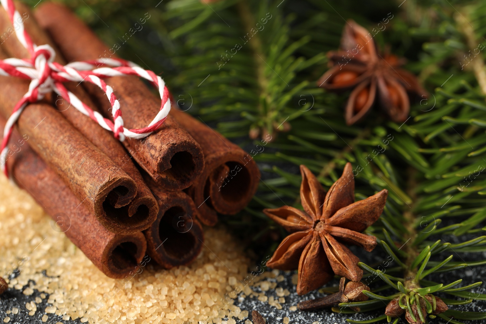 Photo of Different aromatic spices and fir branches on table, closeup