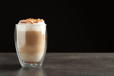 Photo of Glass with delicious caramel frappe on table