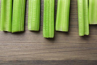 Photo of Fresh green celery on wooden table, flat lay. Space for text