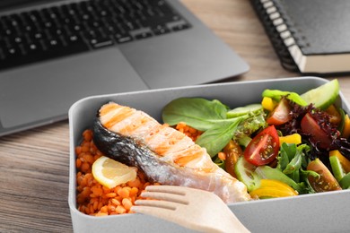 Photo of Healthy products high in vegetable fats near laptop on wooden table, closeup