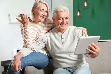 Photo of Mature couple using video chat on tablet at home