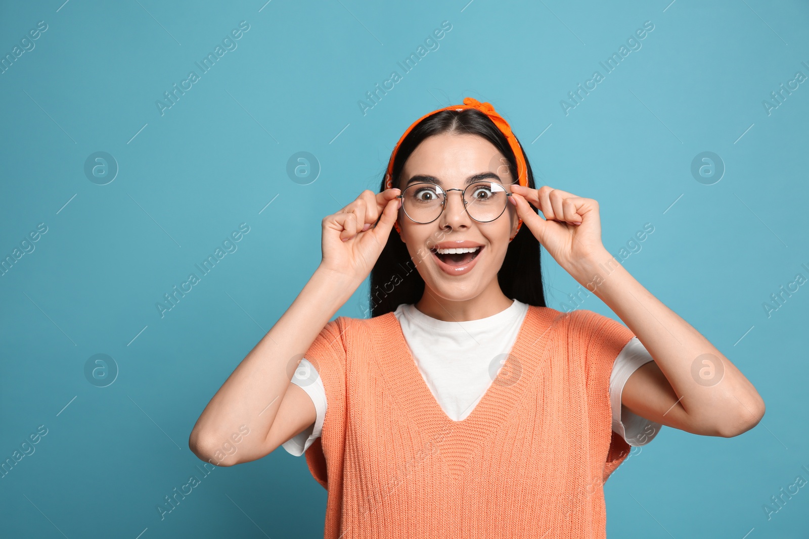Photo of Young woman wearing stylish bandana on light blue background, space for text