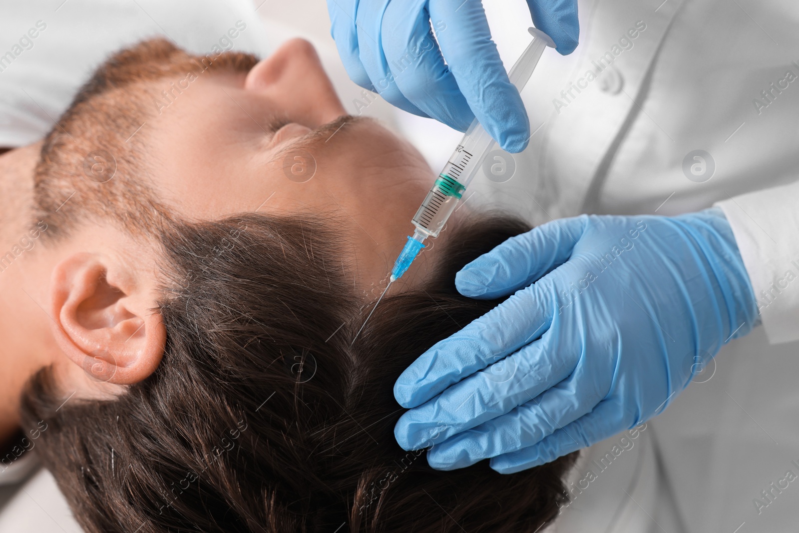 Photo of Trichologist giving injection to patient in clinic, closeup