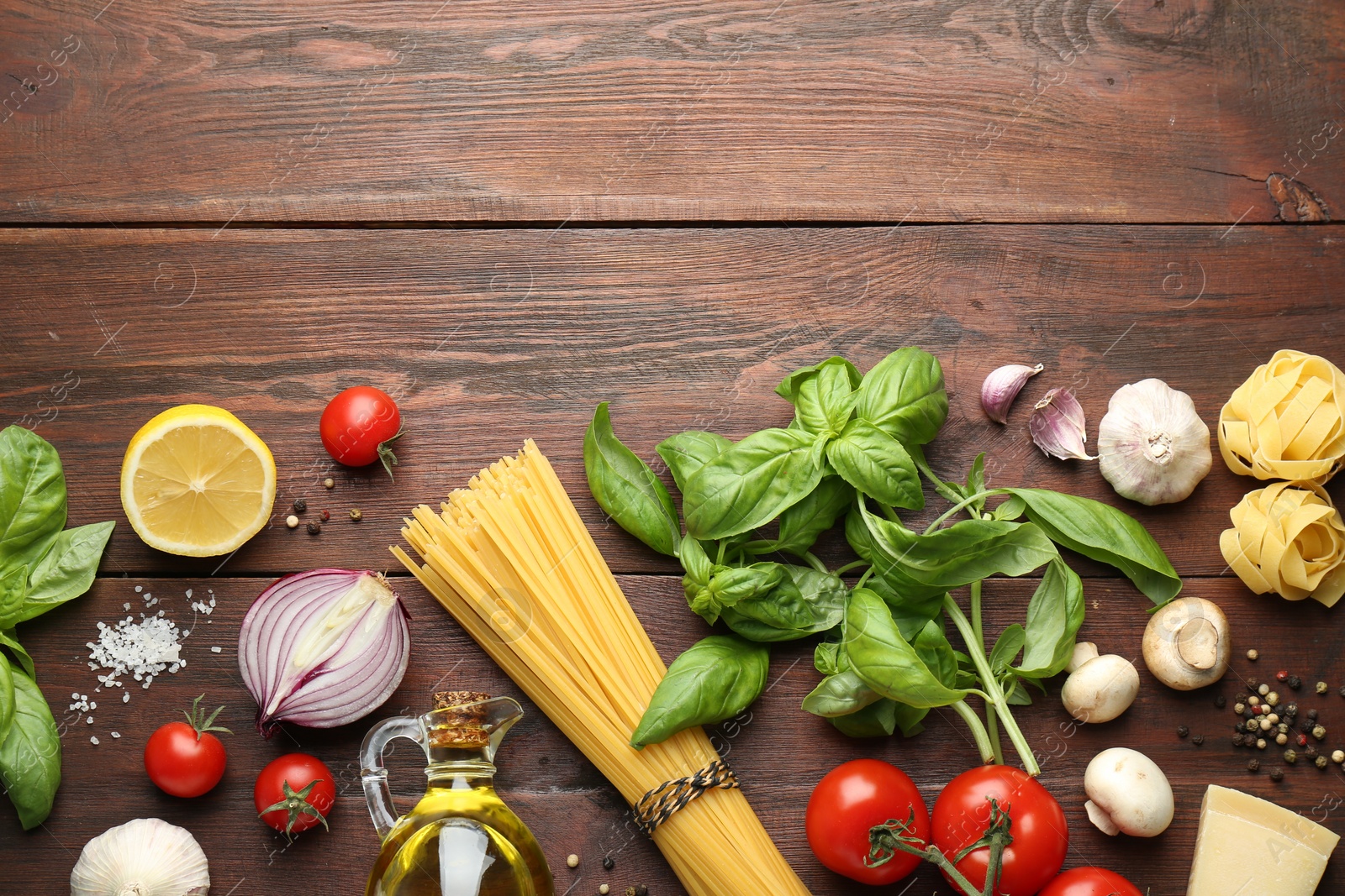 Photo of Different types of pasta, spices and products on wooden table, flat lay. Space for text