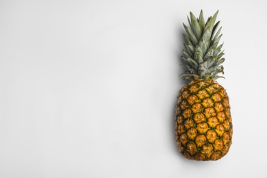 Tasty whole pineapple with leaves on white background, top view