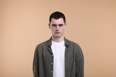 Photo of Portrait of sad man on beige background