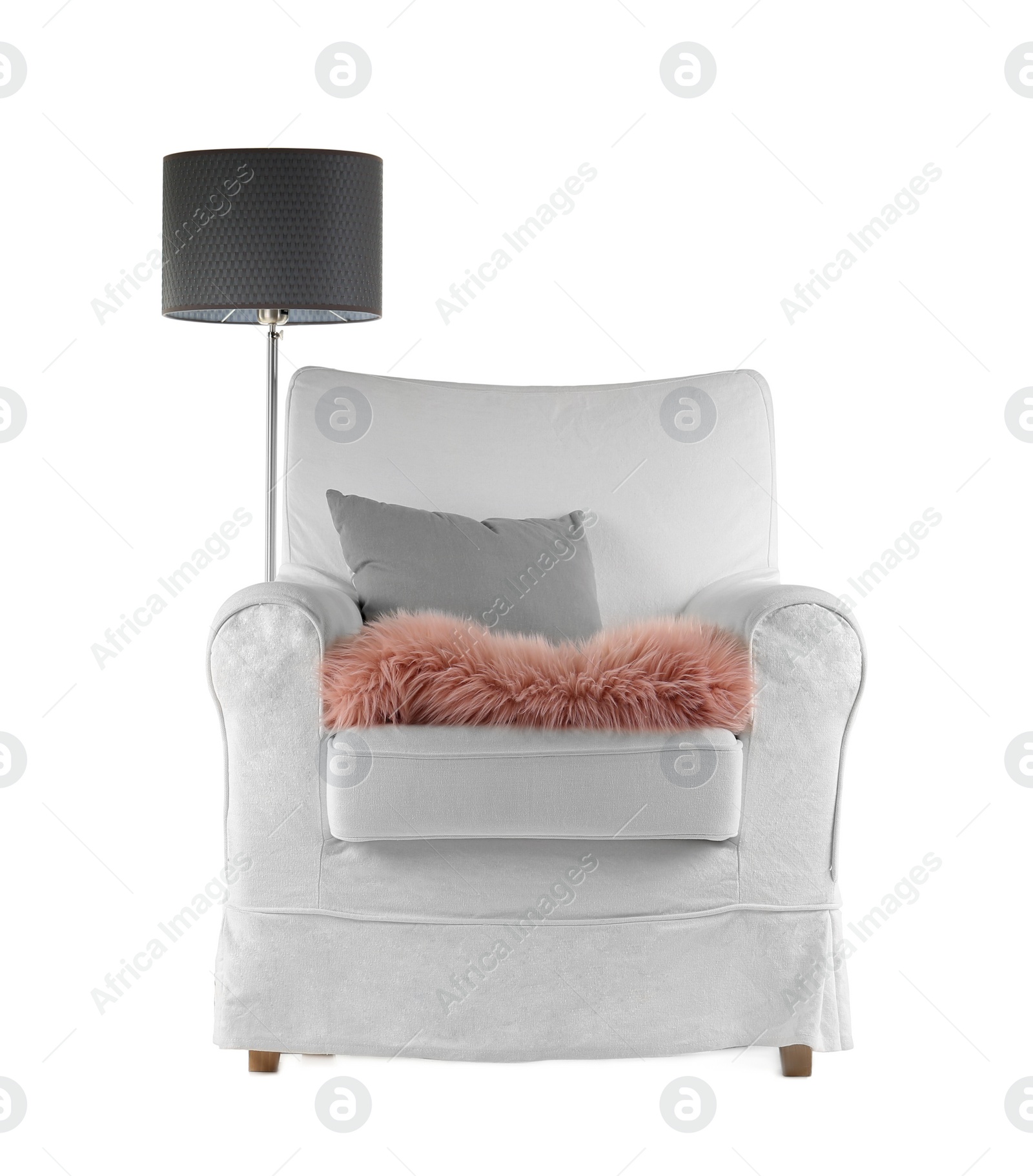 Photo of Comfortable armchair with pillow and lamp on white background