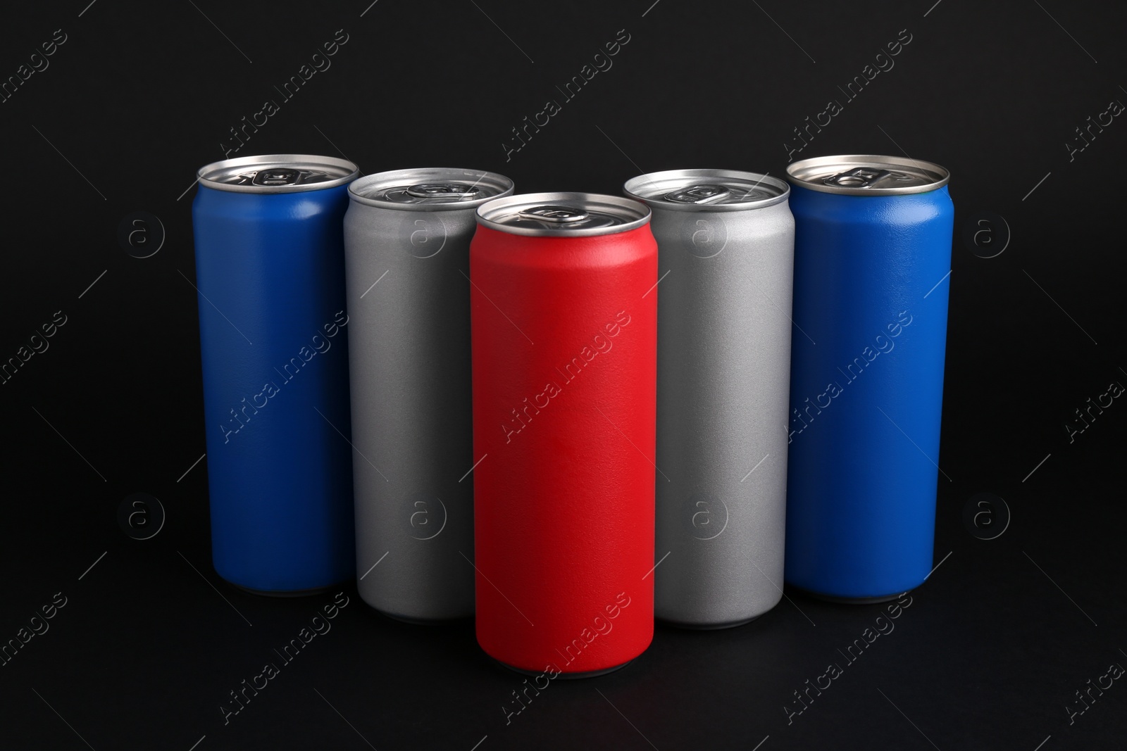 Photo of Energy drinks in colorful cans on black background