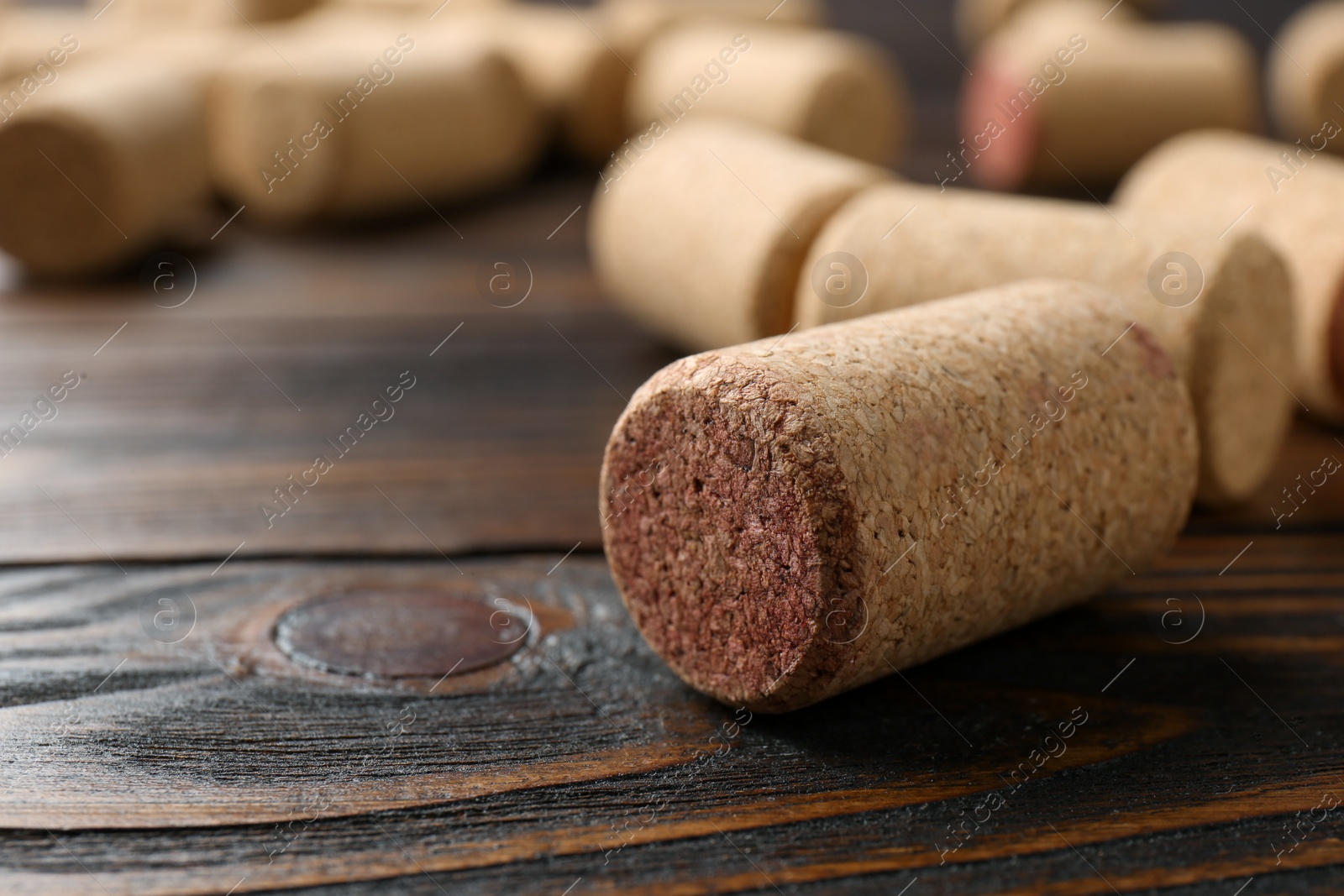 Photo of Many corks of wine bottles on wooden table, closeup