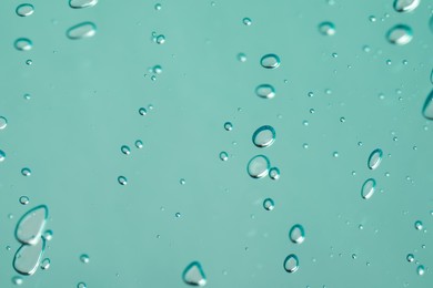Photo of Serum drops on light blue background, closeup