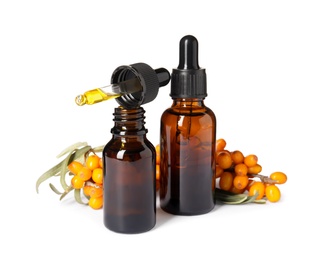 Natural sea buckthorn oil and fresh berries on white background