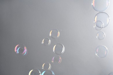 Photo of Beautiful transparent soap bubbles on gray background