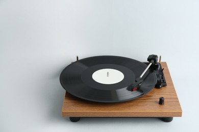 Photo of Turntable with vinyl record on light background. Space for text