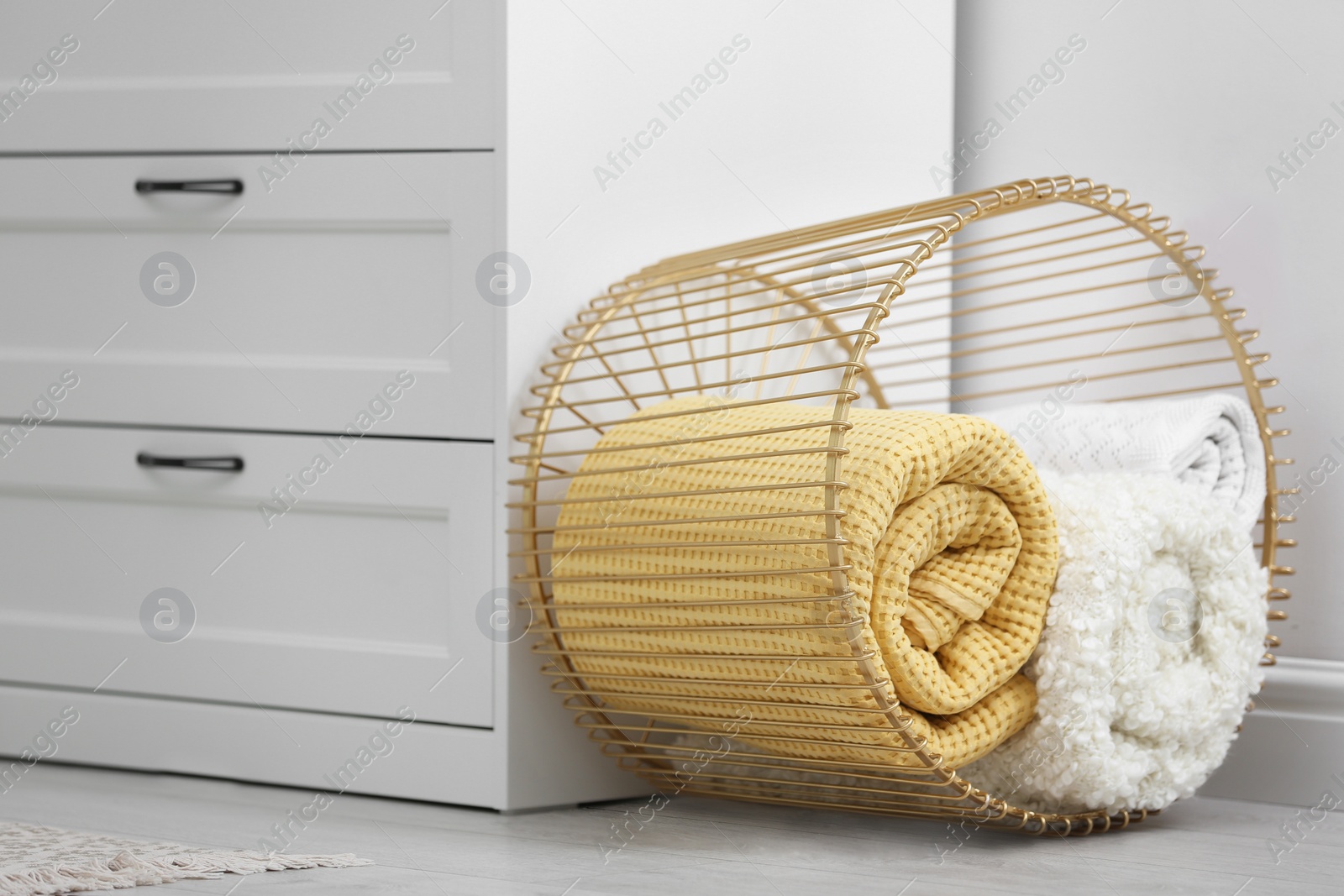 Photo of Basket with soft plaid near commode in room