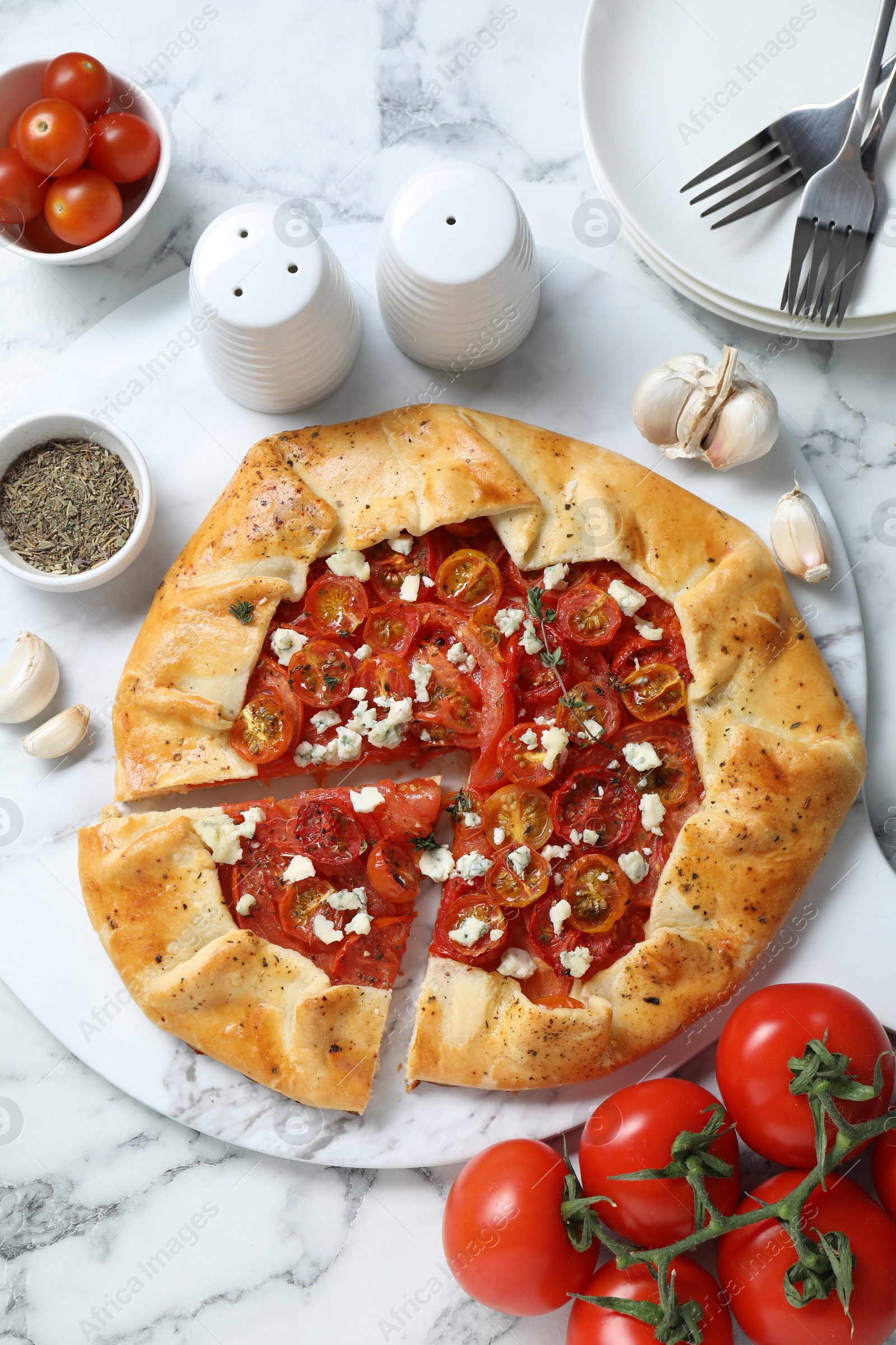 Photo of Flat lay composition of tasty galette with tomato, thyme and cheese (Caprese galette) on white marble table