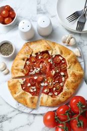 Flat lay composition of tasty galette with tomato, thyme and cheese (Caprese galette) on white marble table