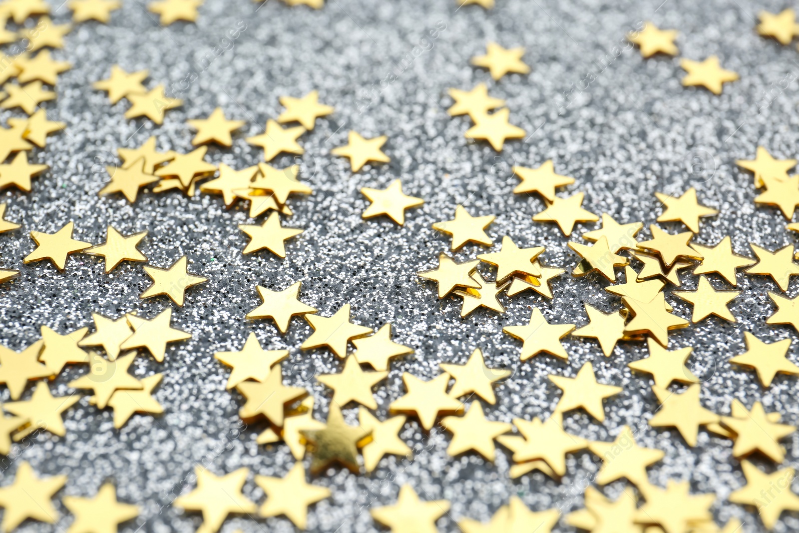 Photo of Confetti stars on grey background, closeup. Christmas celebration