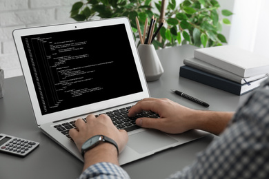 Image of Professional programmer working with laptop in office, closeup