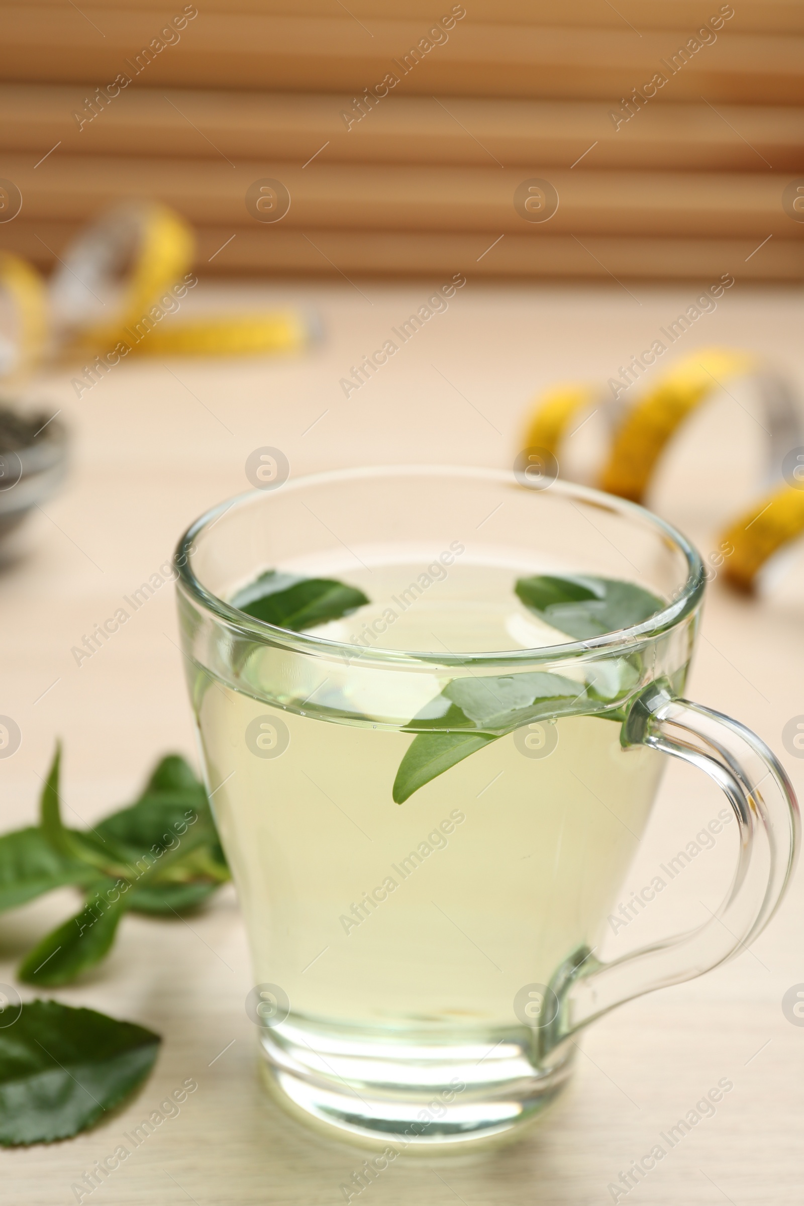 Photo of Diet herbal tea with green leaves on wooden table