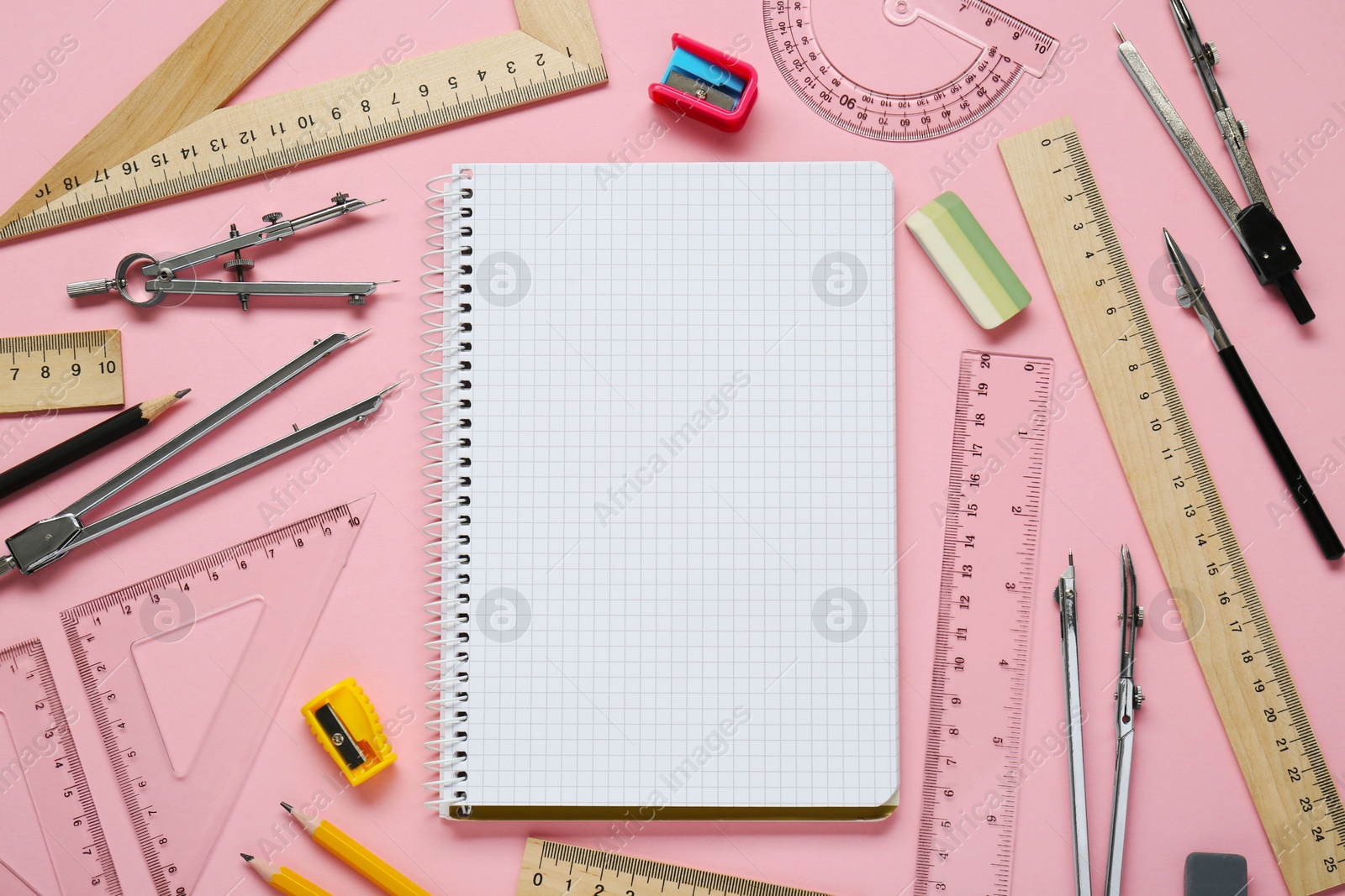 Photo of Flat lay composition with different rulers and stationery on pink background. Space for text