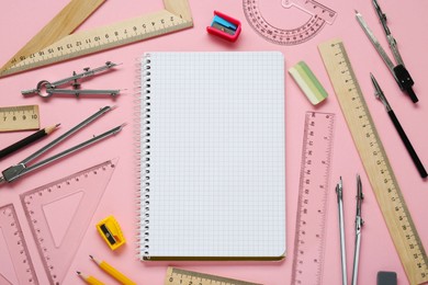 Photo of Flat lay composition with different rulers and stationery on pink background. Space for text