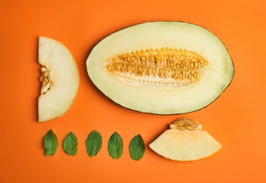 Flat lay composition with melon and mint leaves on color background